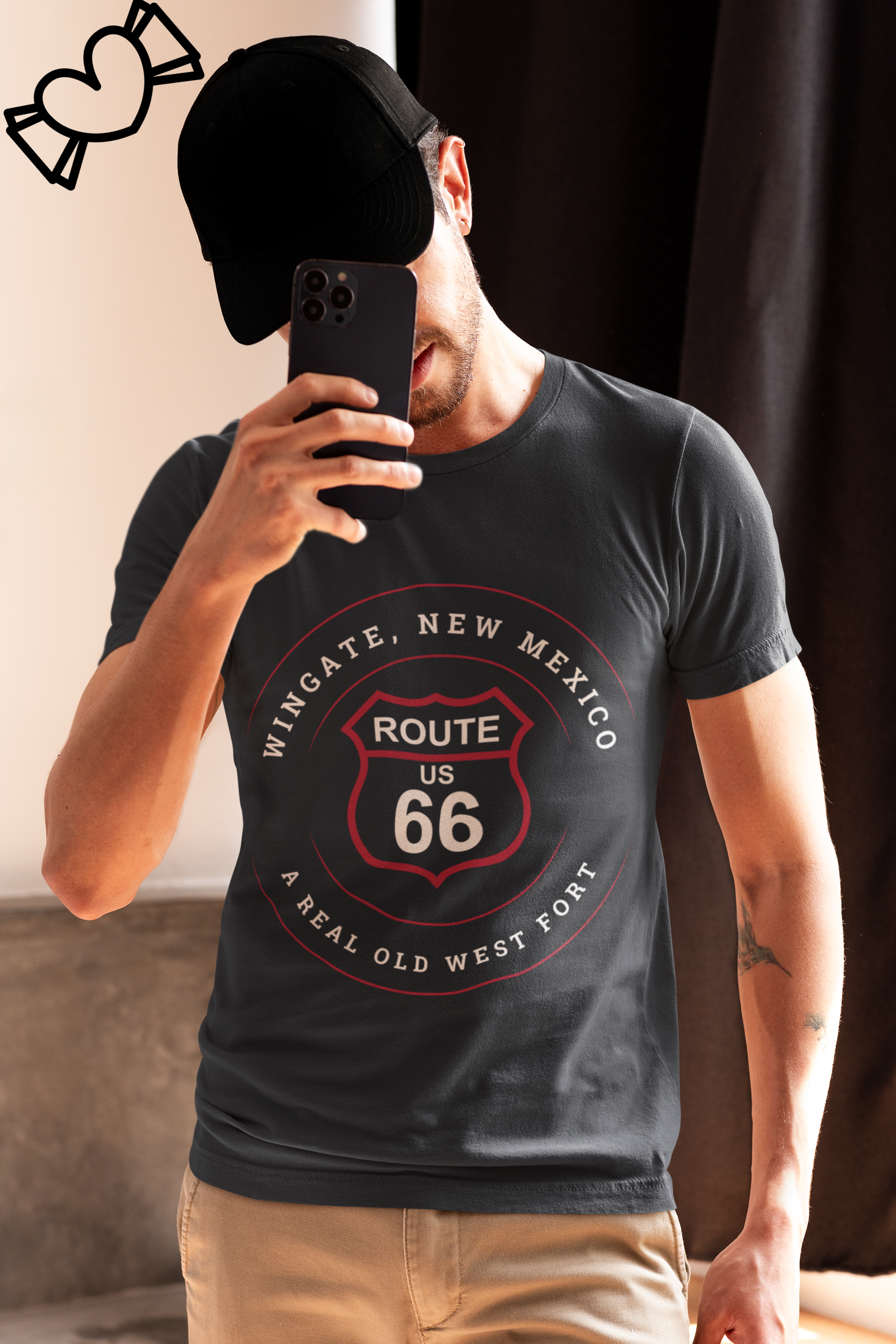 Male model wearing a black baseball cap and a vintage black retro Route 66 unisex jersey tee with Wingate, NM: "A Real Old West Fort" design