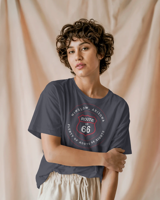 Female model wearing dark grey heather retro Route 66 unisex jersey tee with Winslow, AZ: "Plenty of Route 66 Sights" design