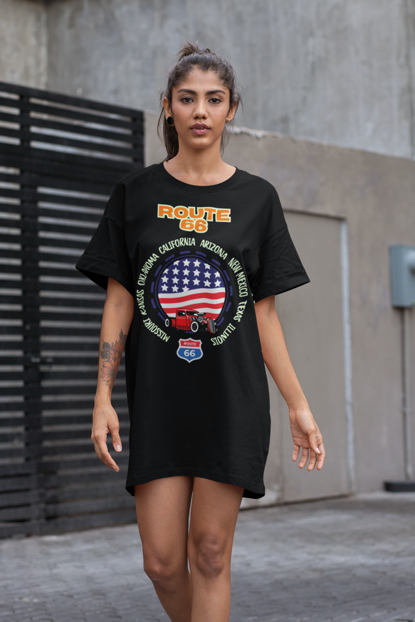 Woman wearing a Route 66 t-shirt dress with U.S. flag and hot rod design, styled casually for a streetwear look. Perfect for traveling, everyday use and summer BBQs.